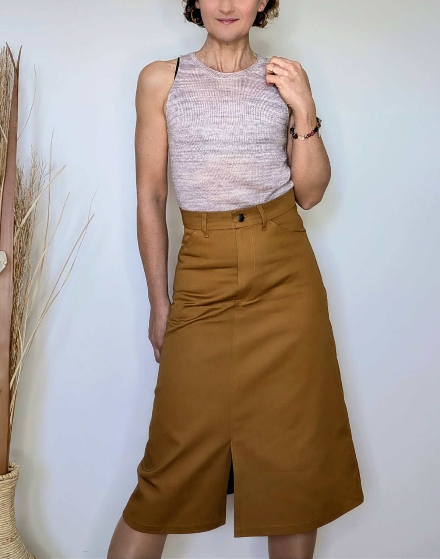 Jupe midi camel femme, coupe évasée avec fente centrale, associée à un top sans manches gris clair.