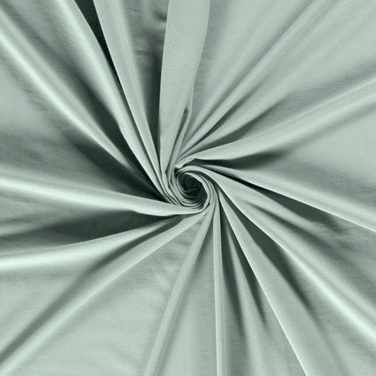 Tissu jersey lisse et doux de couleur vert sauge, plié en spirale au centre pour montrer sa texture souple. - comment coudre du jersey avec une machine